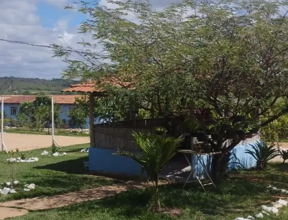 Clínica de Recuperação em Divinópolis - MG Quiosque de telhado colonial e cercado de bambu sob uma árvore grande, com uma mesa de metal ao lado