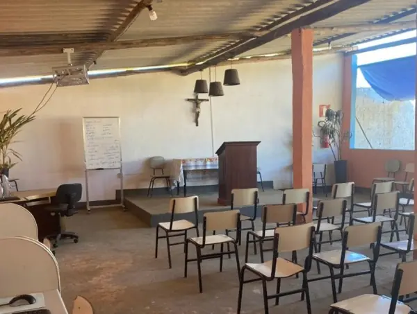 Clínica de Recuperação em Divinópolis - MG Salão coberto com cadeiras enfileiradas, púlpito e quadro branco